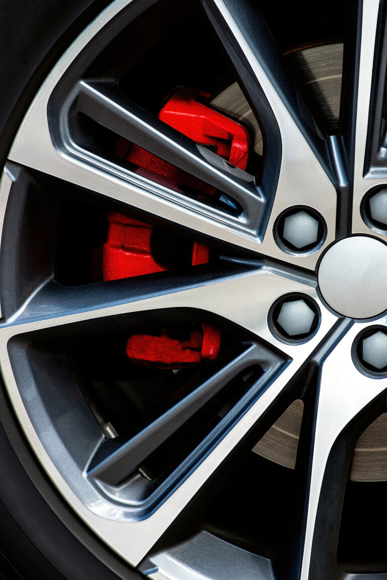 Car wheel close-up with a bright red sports caliper
